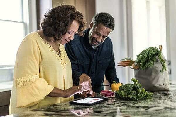 Couple looking at a tablet on the kitchen counter